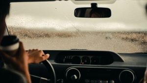 estuurder kijkt door natte voorruit tijdens regenrit – veilig rijden bij slecht zicht en regen