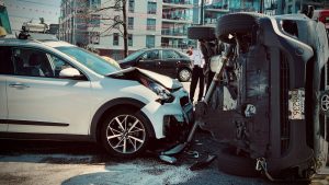 Botsing tussen twee auto’s in stedelijk gebied tijdens eerste rijjaren, met een omgeslagen voertuig en schade