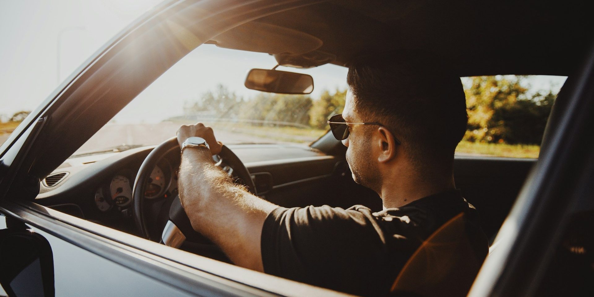 Bestuurder rijdt geconcentreerd tijdens eerste rijjaren, met beide handen aan het stuur in zonnige omstandigheden