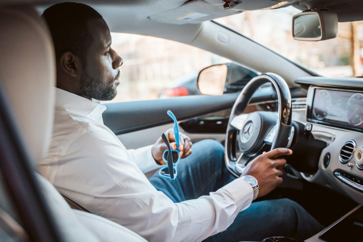 Auto zakelijk gebruiken door ondernemer die onderweg is en rijdt in moderne personenauto