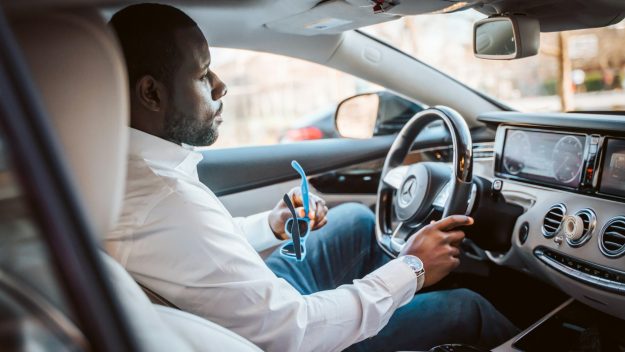 Auto zakelijk gebruiken door ondernemer die onderweg is en rijdt in moderne personenauto
